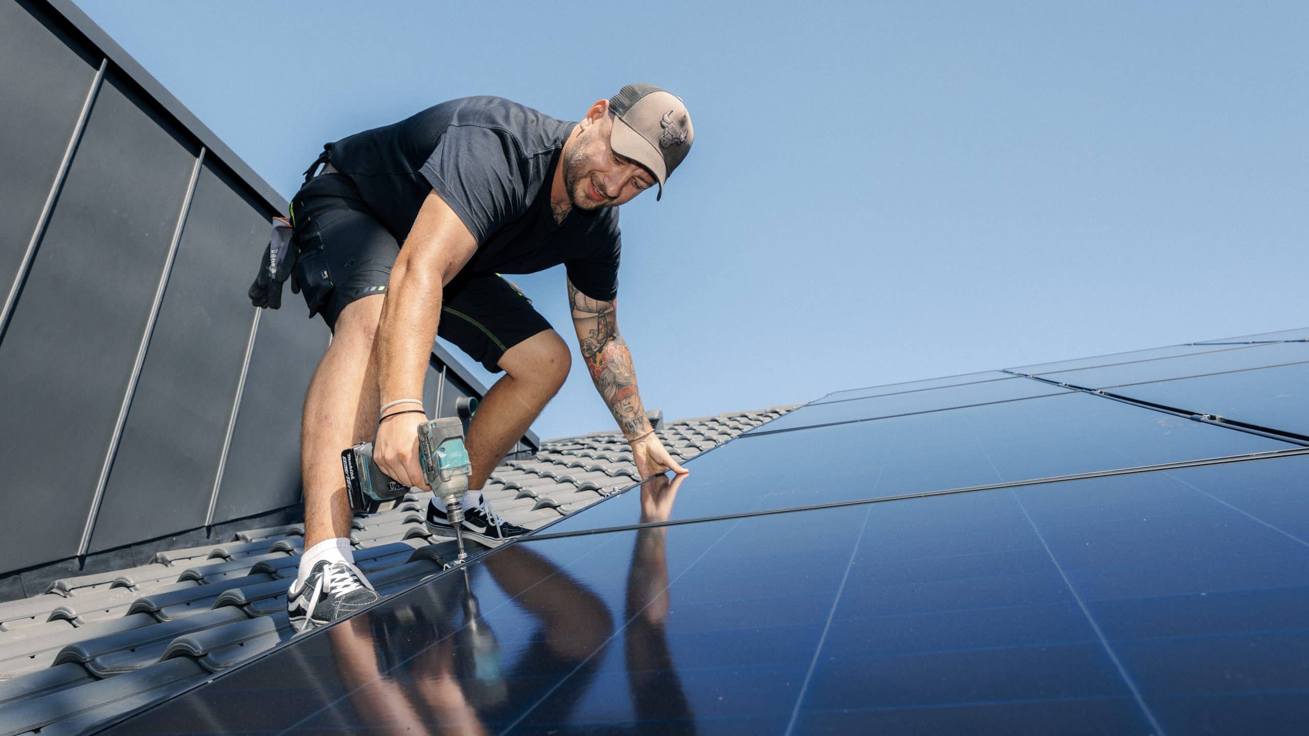 Mitarbeiter installier PV-Anlage auf einem Dach.