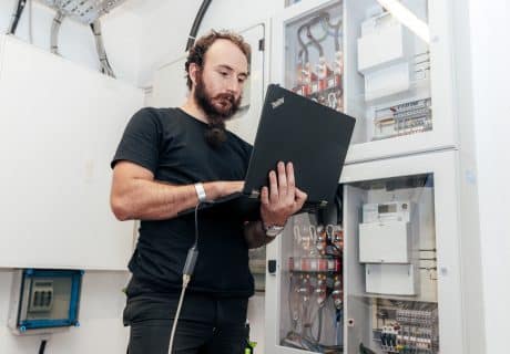 Mitarbeiter bei der Installation eines Stromspeichers, den wir ebenfalls empfehlen, wenn Sie eine PV Anlage kaufen